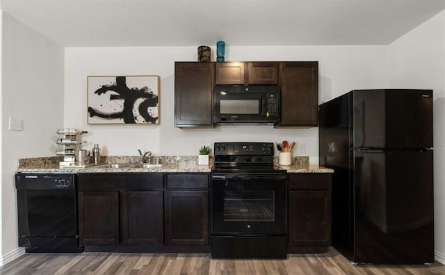 710 S 20th St, Temple, TX 76501 - kitchen featuring black appliances, light wood-style flooring, a sink, light stone countertops, and dark brown cabinets