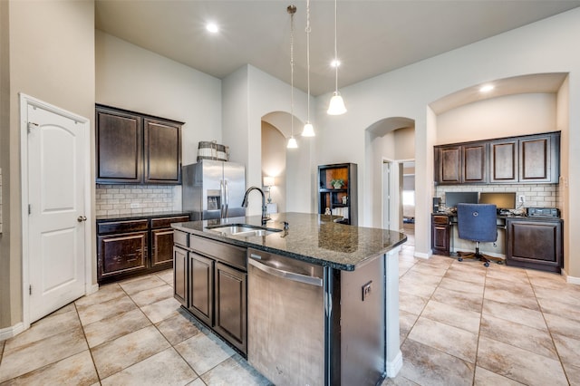 2617 Castle Creek Dr, Little Elm, TX 75068 - kitchen featuring appliances with stainless steel finishes, a sink, arched walkways, decorative backsplash, and recessed lighting