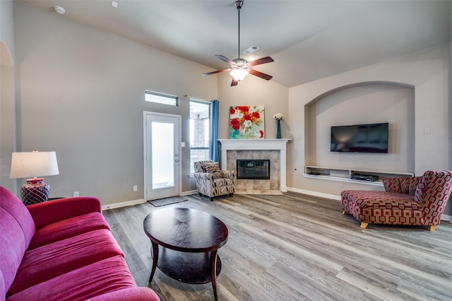2617 Castle Creek Dr, Little Elm, TX 75068 - living area featuring wood finished floors, a tiled fireplace, a ceiling fan, baseboards, and vaulted ceiling