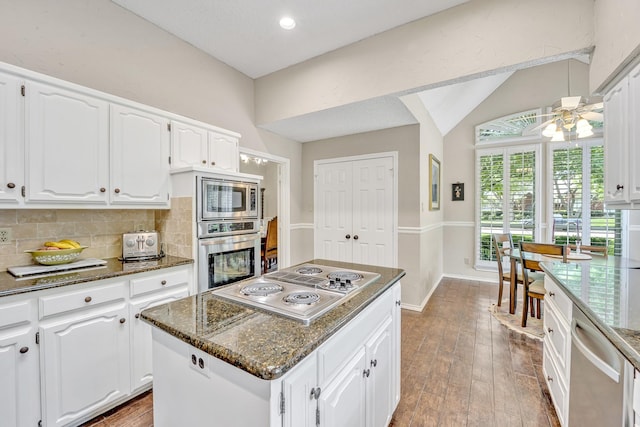 kitchen with stainless steel appliances, ceiling fan, decorative backsplash, white cabinetry, and dark stone countertops
