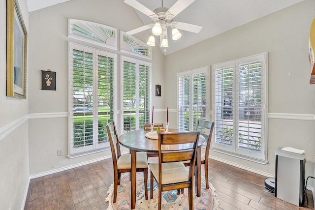 dining room featuring lofted ceiling, wood finished floors, ceiling fan, and baseboards