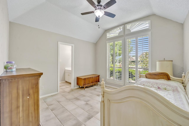 bedroom featuring vaulted ceiling, a textured ceiling, baseboards, a ceiling fan, and ensuite bathroom