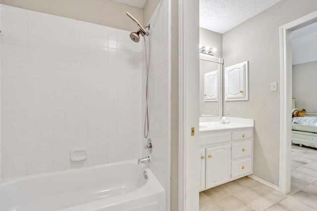 ensuite bathroom featuring tile patterned flooring, shower / washtub combination, a textured ceiling, and vanity