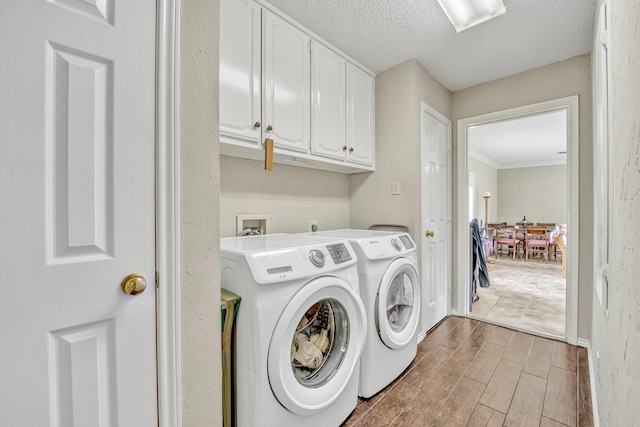 clothes washing area with cabinet space, separate washer and dryer, wood tiled floors, crown molding, and a textured ceiling