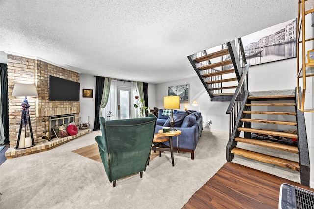 10607 Hillpoint Dr, Dallas, TX 75238 - living area with stairs, a textured ceiling, wood finished floors, a fireplace, and baseboards