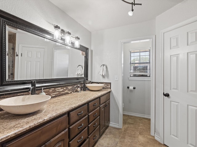 402 Brookview Dr, Decatur, TX 76234 - bathroom with decorative backsplash, double vanity, baseboards, and tile patterned floors