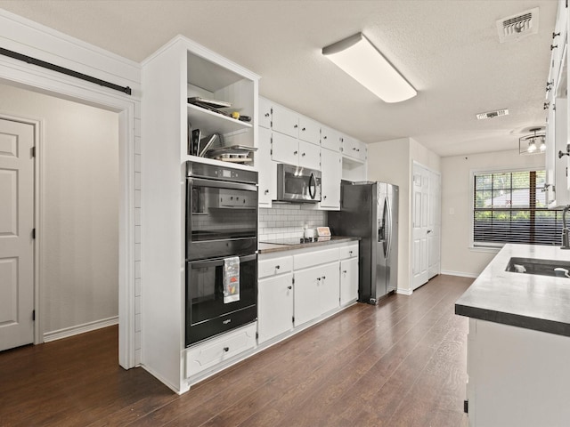 402 Brookview Dr, Decatur, TX 76234 - kitchen with black appliances, a sink, backsplash, baseboards, and white cabinets