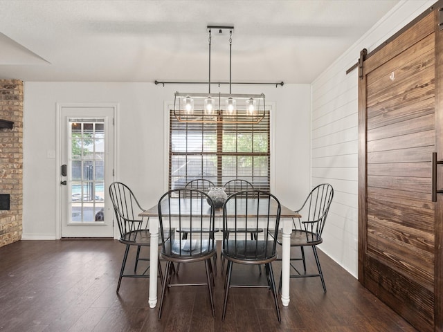 402 Brookview Dr, Decatur, TX 76234 - dining space featuring dark wood-style flooring, a barn door, baseboards, and a stone fireplace