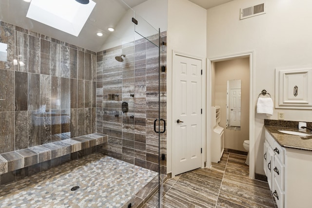 1141 Yorkshire Dr, Carrollton, TX 75007 - full bathroom with a skylight, a shower stall, toilet, vanity, and lofted ceiling