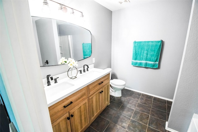 1433 Sun Breeze Dr, Little Elm, TX 75068 - bathroom featuring toilet, double vanity, tile patterned flooring, and baseboards
