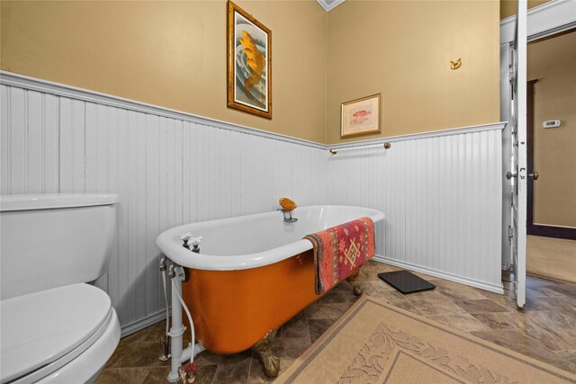 403 S Royall, Palestine, TX 75801 - bathroom with toilet, a wainscoted wall, a freestanding bath, and baseboards