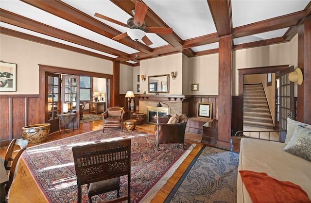403 S Royall, Palestine, TX 75801 - living area with a wainscoted wall, wood finished floors, a glass covered fireplace, beam ceiling, and ceiling fan