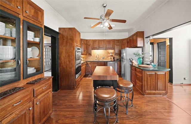 403 S Royall, Palestine, TX 75801 - kitchen with appliances with stainless steel finishes, a sink, ceiling fan, wood finished floors, and decorative backsplash