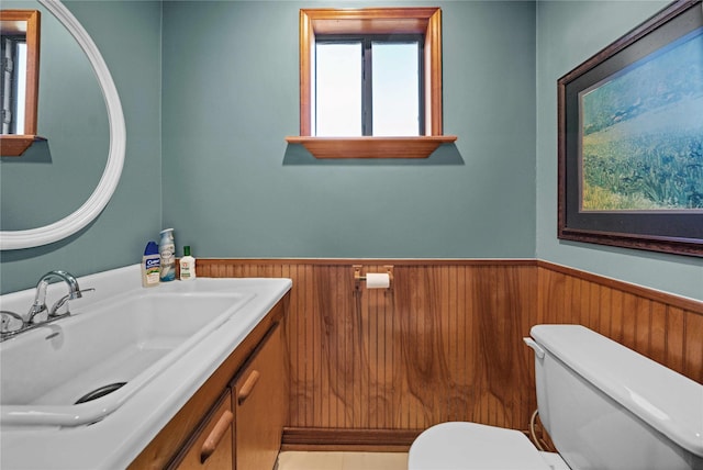 403 S Royall, Palestine, TX 75801 - half bathroom featuring wainscoting, toilet, vanity, and wooden walls