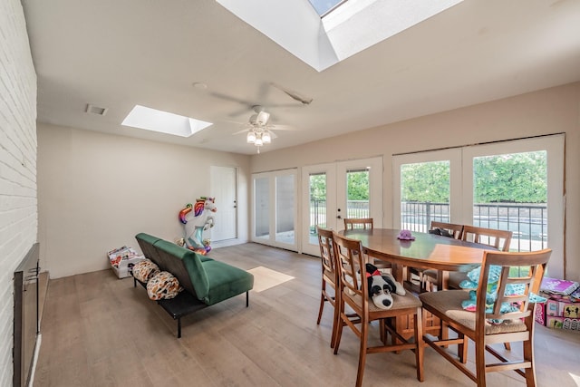 707 Kyle Dr, Arlington, TX 76011 - dining room featuring a skylight, french doors, light wood-style floors, and ceiling fan