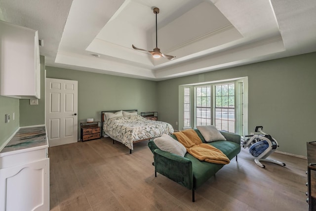 707 Kyle Dr, Arlington, TX 76011 - bedroom featuring a raised ceiling, wood finished floors, and a ceiling fan