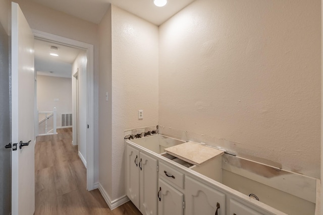 707 Kyle Dr, Arlington, TX 76011 - bathroom featuring wood finished floors, a textured wall, and baseboards