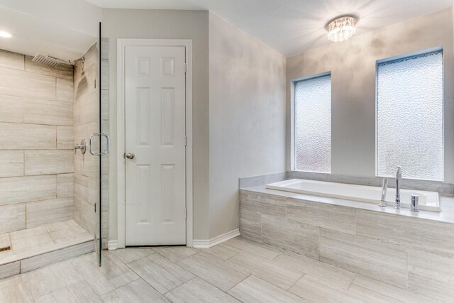 10014 Silver Creek Rd, Dallas, TX 75243 - bathroom with a garden tub, a shower stall, and a chandelier