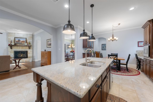8803 Kelvington Dr, Frisco, TX 75035 - kitchen with a sink, a chandelier, arched walkways, ornamental molding, and recessed lighting