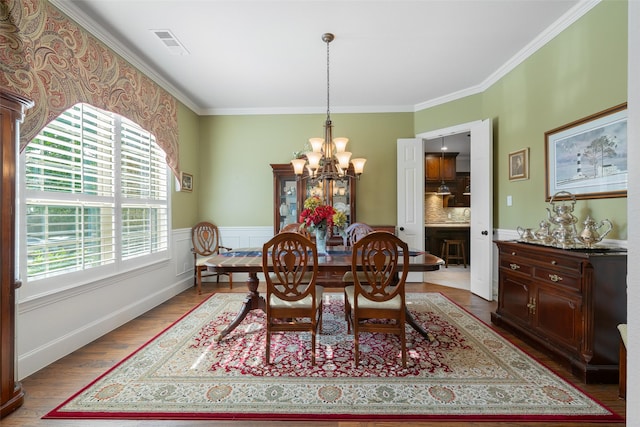 8803 Kelvington Dr, Frisco, TX 75035 - dining area with a chandelier, wood finished floors, and ornamental molding