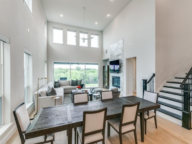 4837 Cumberland Cir, Carrollton, TX 75010 - dining room with a towering ceiling, stairway, light wood-type flooring, recessed lighting, and a premium fireplace