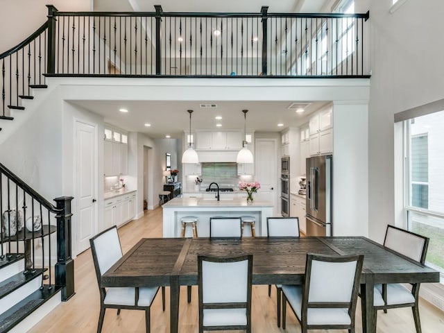 4837 Cumberland Cir, Carrollton, TX 75010 - dining space with stairs, a high ceiling, light wood-type flooring, baseboards, and recessed lighting