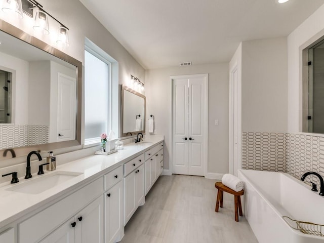 4837 Cumberland Cir, Carrollton, TX 75010 - full bath featuring double vanity, a soaking tub, and baseboards
