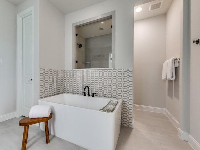 4837 Cumberland Cir, Carrollton, TX 75010 - bathroom with a soaking tub, a tile shower, baseboards, and tile patterned flooring
