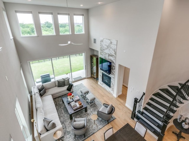 4837 Cumberland Cir, Carrollton, TX 75010 - living room featuring a high ceiling, a high end fireplace, wood finished floors, stairway, and recessed lighting