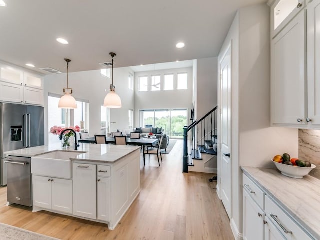 4837 Cumberland Cir, Carrollton, TX 75010 - kitchen with dishwasher, a sink, high end fridge, white cabinetry, and light wood-style flooring