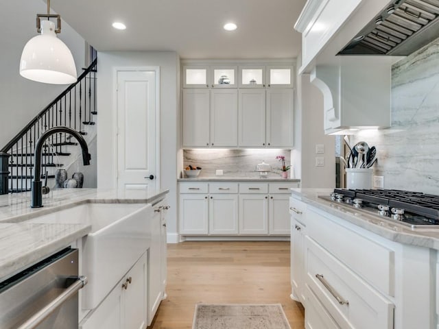 4837 Cumberland Cir, Carrollton, TX 75010 - kitchen with appliances with stainless steel finishes, custom range hood, tasteful backsplash, a sink, and light wood-style floors