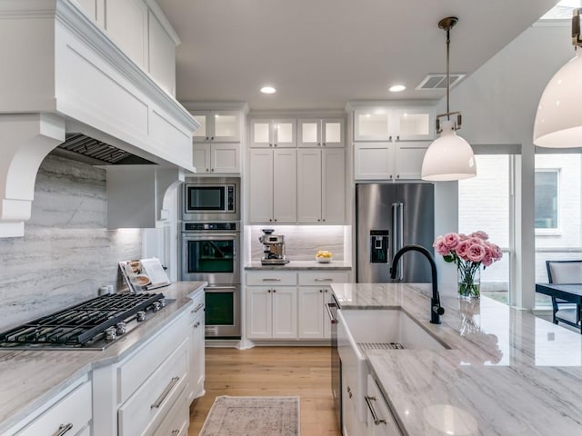 4837 Cumberland Cir, Carrollton, TX 75010 - kitchen with stainless steel appliances, custom range hood, tasteful backsplash, white cabinets, and recessed lighting