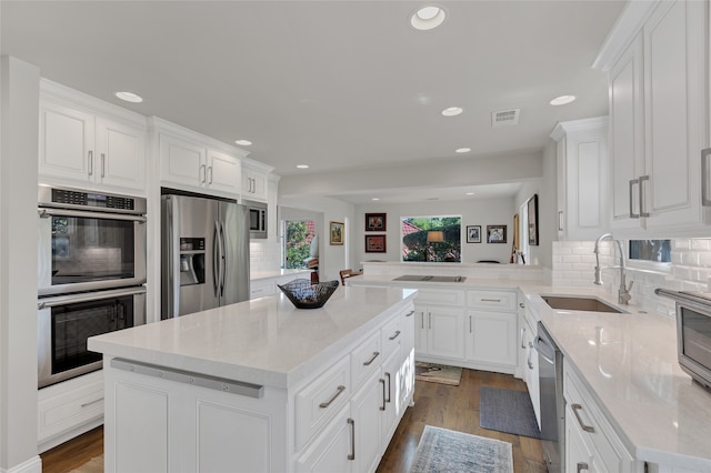 3405 Waterview Trl, Rockwall, TX 75087 - kitchen with appliances with stainless steel finishes, a sink, decorative backsplash, white cabinetry, and recessed lighting