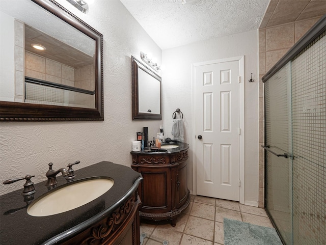 4029 Aragon Dr, Fort Worth, TX 76133 - bathroom with a stall shower, two vanities, a textured ceiling, a textured wall, and tile patterned flooring