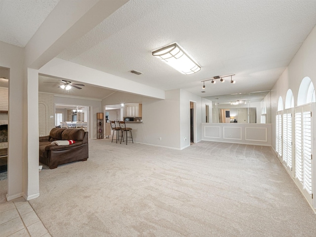 4029 Aragon Dr, Fort Worth, TX 76133 - living room with a ceiling fan, plenty of natural light, carpet flooring, a fireplace, and a textured ceiling
