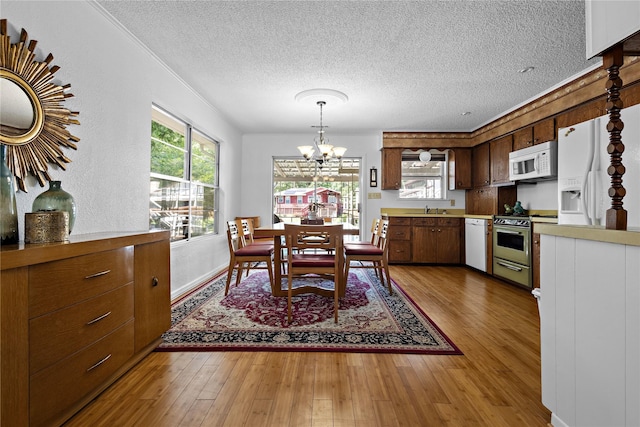 210 Harbor Dr, Gun Barrel City, TX 75156 - dining room with a chandelier, wood finished floors, and a textured ceiling