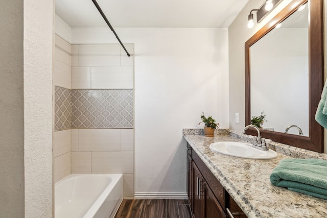 3843 Bernal Dr, Dallas, TX 75212 - full bath with wood finished floors, vanity, baseboards, shower / tub combination, and a textured wall