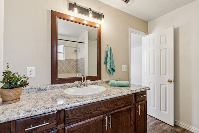 3843 Bernal Dr, Dallas, TX 75212 - full bathroom featuring vanity, a shower, and wood finished floors