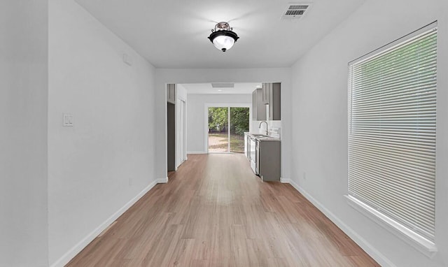1413 Shelburne St, Waco, TX 76711 - hall with a sink, light wood finished floors, and baseboards