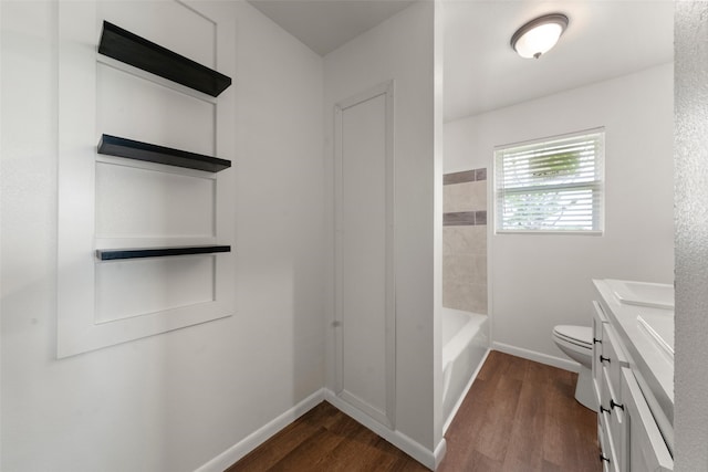 527 Dison Dr, Waco, TX 76706 - bathroom featuring wood finished floors, toilet, baseboards, a bathtub, and vanity