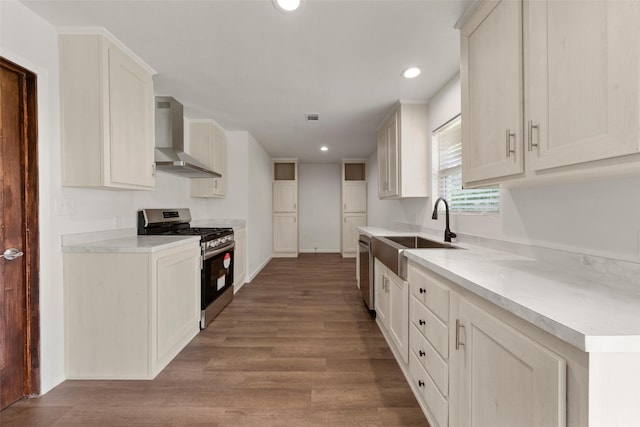 527 Dison Dr, Waco, TX 76706 - kitchen with stainless steel appliances, wall chimney range hood, a sink, recessed lighting, and wood finished floors