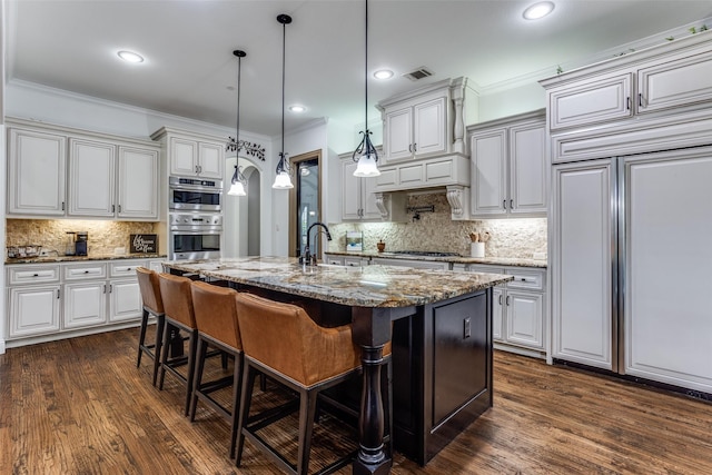 1716 Caman Park Dr, Lucas, TX 75002 - kitchen featuring paneled built in refrigerator, crown molding, backsplash, a breakfast bar, and white cabinetry