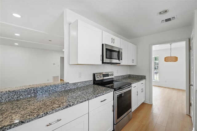 700 Brentwood Ln, Richardson, TX 75080 - kitchen with appliances with stainless steel finishes, white cabinets, dark stone counters, light wood-type flooring, and recessed lighting
