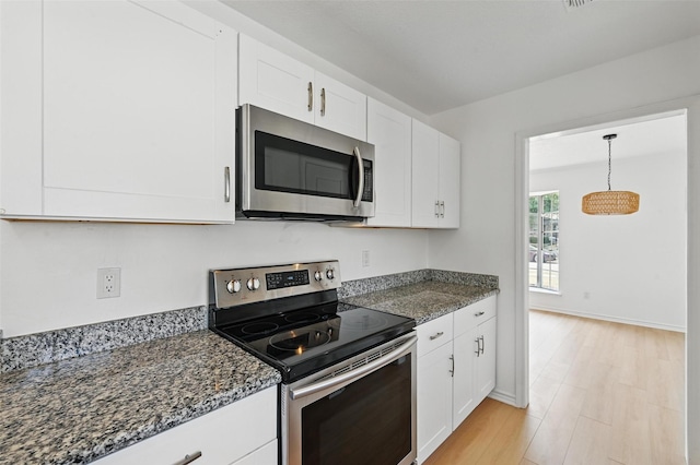 700 Brentwood Ln, Richardson, TX 75080 - kitchen featuring appliances with stainless steel finishes, white cabinetry, dark stone counters, and light wood-type flooring