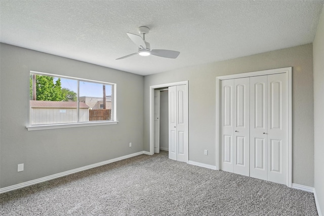 700 Brentwood Ln, Richardson, TX 75080 - unfurnished bedroom with multiple closets, carpet, baseboards, a textured ceiling, and a ceiling fan