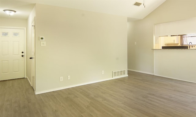 602 Valleyridge Ct, Decatur, TX 76234 - unfurnished living room featuring wood finished floors, baseboards, lofted ceiling, and a sink