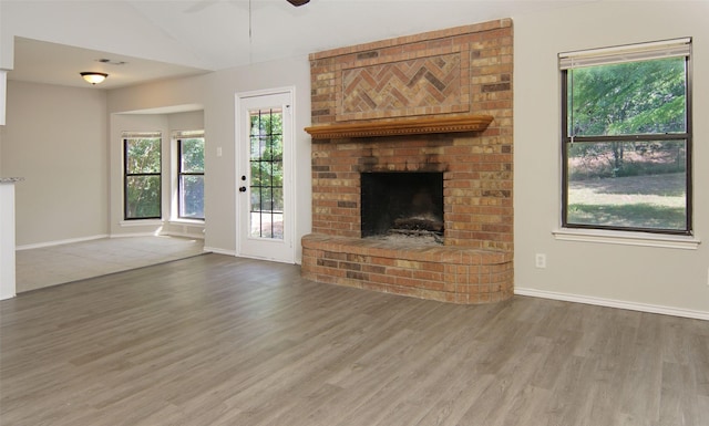 602 Valleyridge Ct, Decatur, TX 76234 - unfurnished living room featuring wood finished floors, a fireplace, vaulted ceiling, a ceiling fan, and baseboards