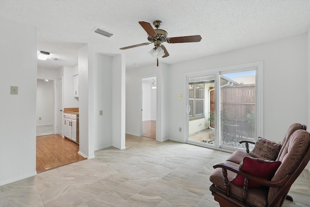 4448 Wind River Ln, Garland, TX 75042 - living area with a ceiling fan and a textured ceiling