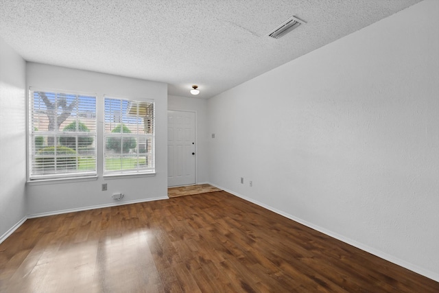 4448 Wind River Ln, Garland, TX 75042 - unfurnished room with wood finished floors, a textured ceiling, and baseboards