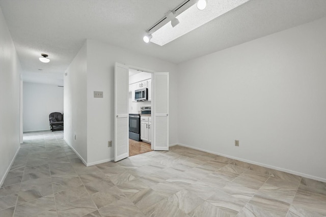 4448 Wind River Ln, Garland, TX 75042 - spare room with a textured ceiling and baseboards